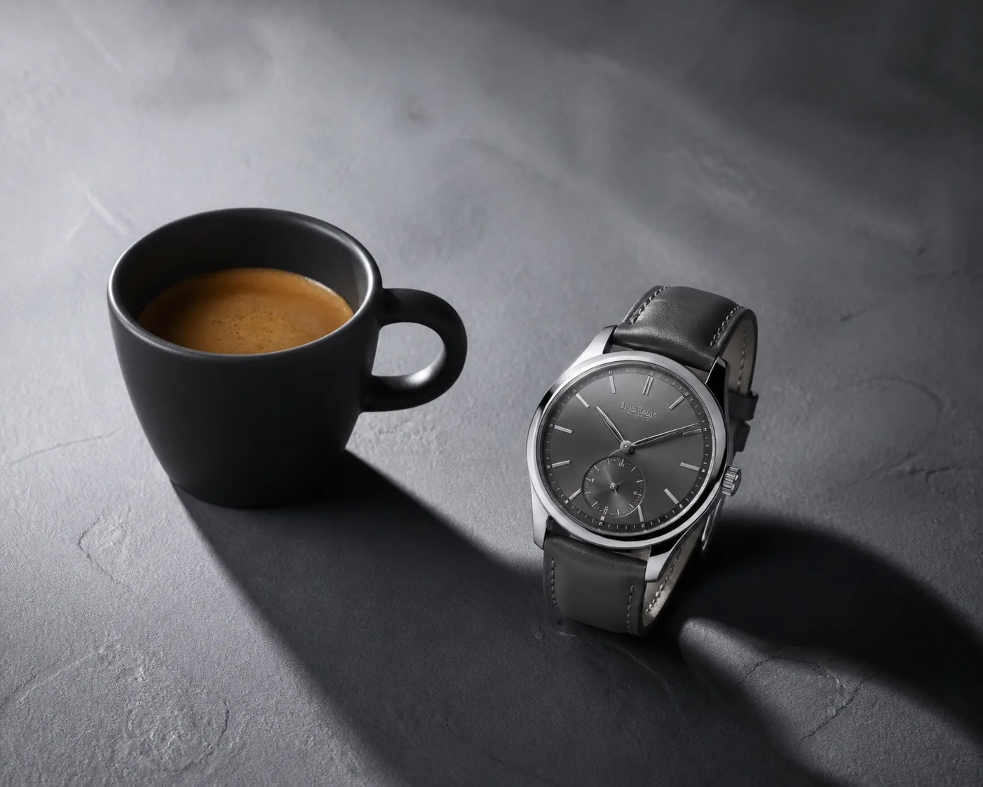 Still life di tazzina in ceramica e orologio su ardesia